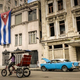 A bike-taxi and a vintage American car are seen in front of a building decorated with a large Cuban flag on Dec. 31, 2013, in Havana.
ADALBERTO ROQUE/AFP/Getty Images